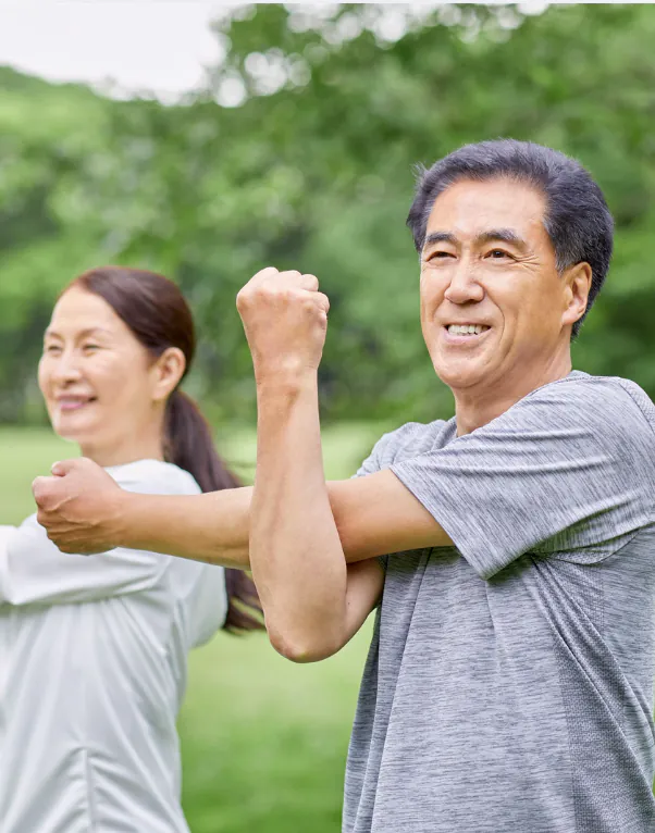 一對中年男女在戶外做伸展運動